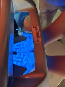 Hände leuchten blau unterm Fluoreszenztester