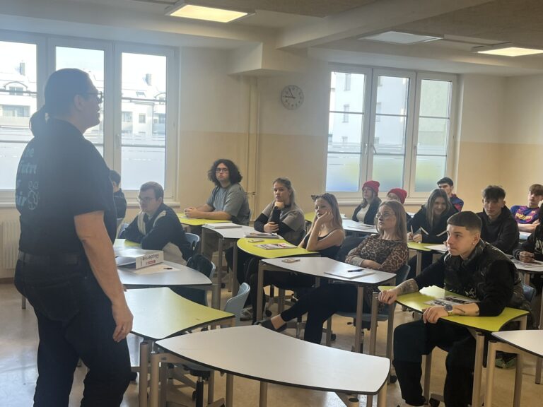Ein Mann steht im Klassenzimmer vor den Schülerinnen und Schülern für einen Vortrag über Fairtrade