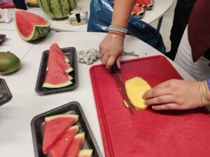 geschnittene Wassermelone und Mango am Schneidbrett wird gerade geschnitten